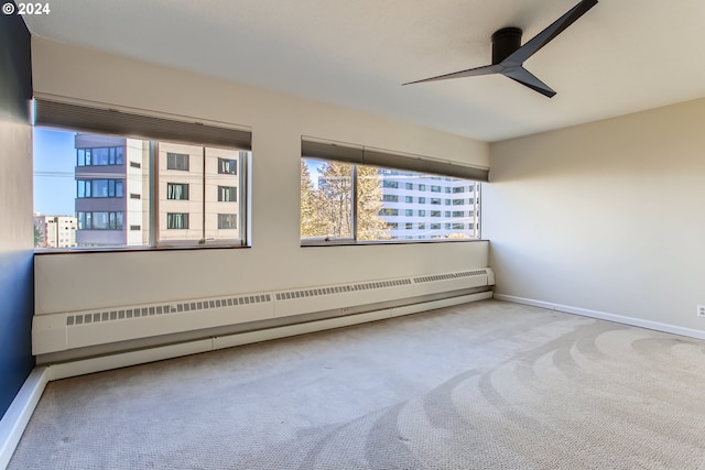 empty room featuring ceiling fan, light carpet, and a baseboard heating unit