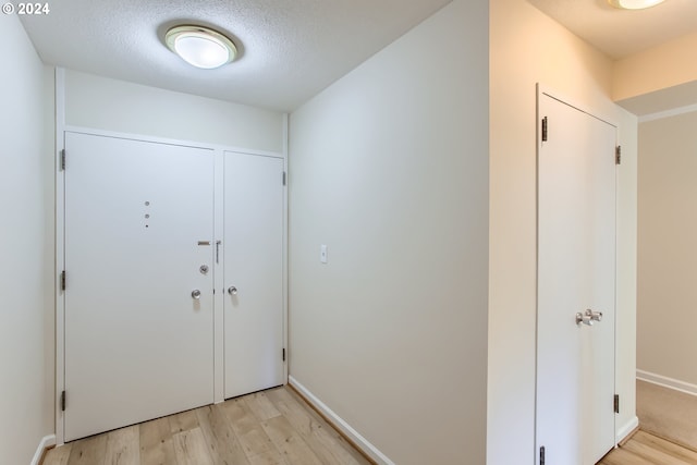 foyer with a textured ceiling and light wood-type flooring