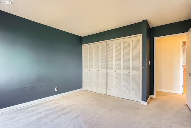 unfurnished bedroom featuring a closet and light colored carpet