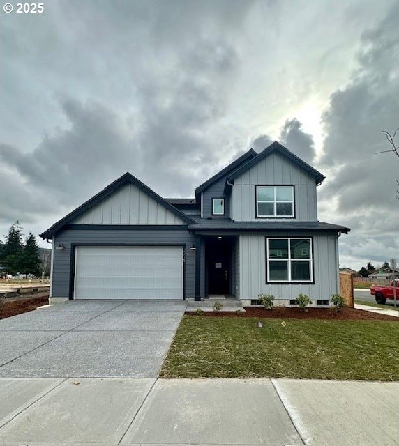 view of front facade featuring driveway, board and batten siding, an attached garage, and a front yard