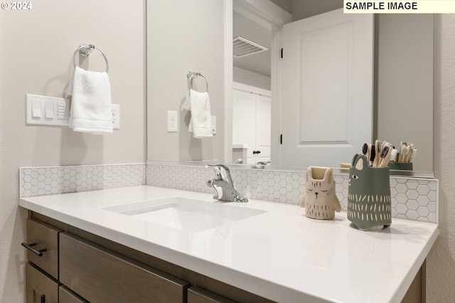 bathroom with vanity and tasteful backsplash