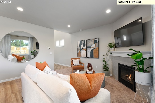 living room featuring a tile fireplace and light hardwood / wood-style floors