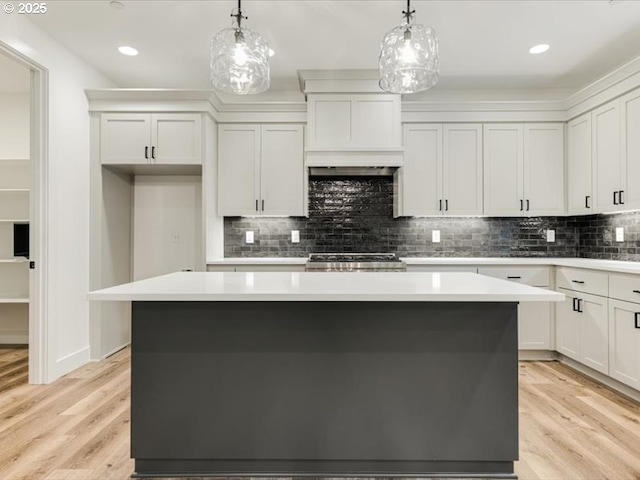 kitchen with white cabinetry, hanging light fixtures, and a kitchen island