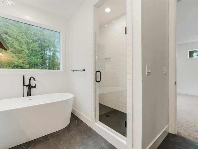 bathroom featuring a healthy amount of sunlight and separate shower and tub