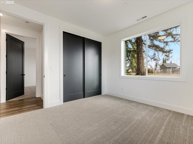 unfurnished bedroom with a closet and carpet flooring