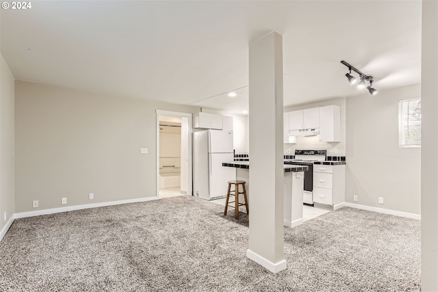 kitchen with a kitchen bar, white cabinetry, light colored carpet, and white appliances