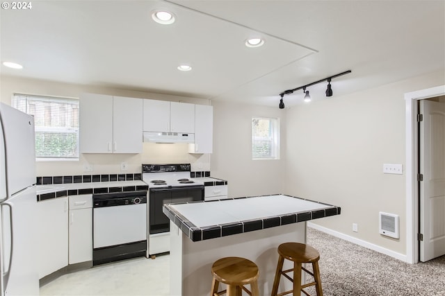 kitchen with white cabinetry, tile counters, a healthy amount of sunlight, and white appliances