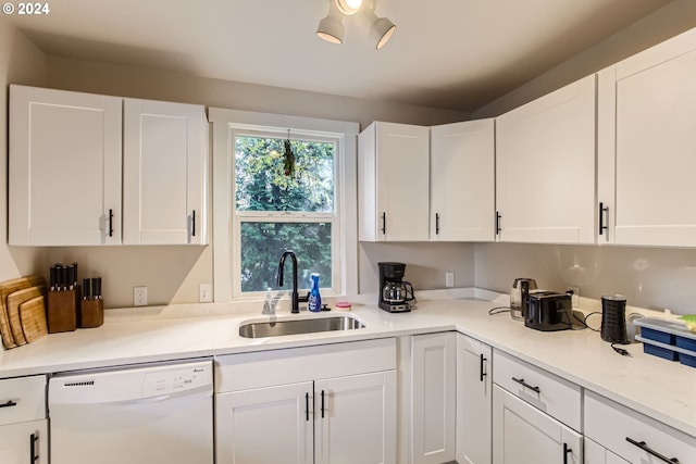 kitchen with white cabinetry, dishwasher, and sink