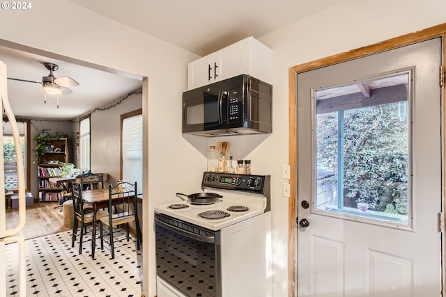 5108 NE Glisan St, Portland, OR 97213 - kitchen featuring black microwave, white electric stove, plenty of natural light, and white cabinetry
