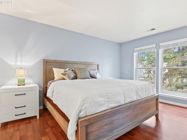 bedroom with dark hardwood / wood-style flooring