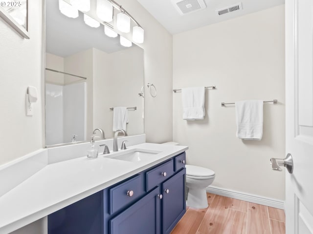 bathroom featuring hardwood / wood-style floors, toilet, a shower, and vanity