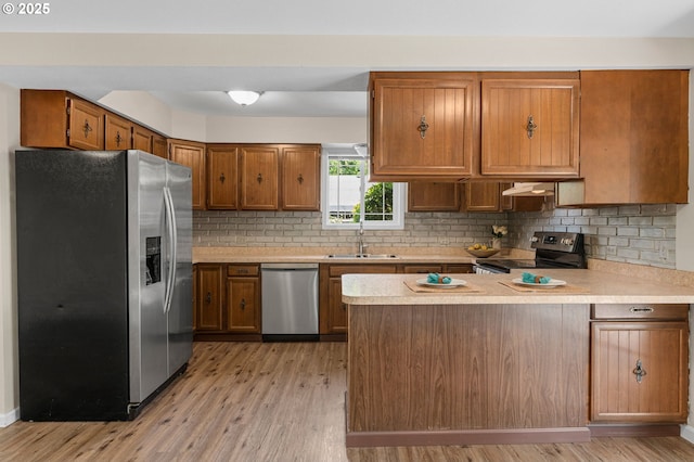 5706 NE 58th Ct, Vancouver, WA 98661 - kitchen with appliances with stainless steel finishes, a peninsula, light countertops, light wood-style floors, and brown cabinets