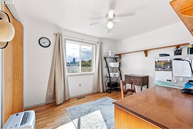 home office with ceiling fan, light wood-style flooring, and visible vents