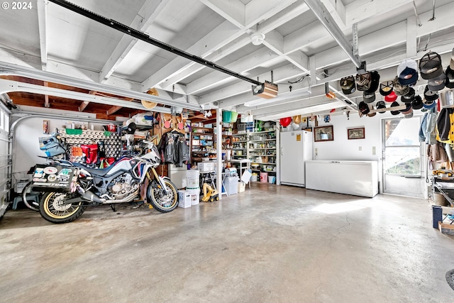 garage with a garage door opener, fridge, and freestanding refrigerator