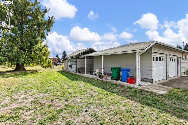 exterior space featuring an outdoor structure, a yard, and a garage