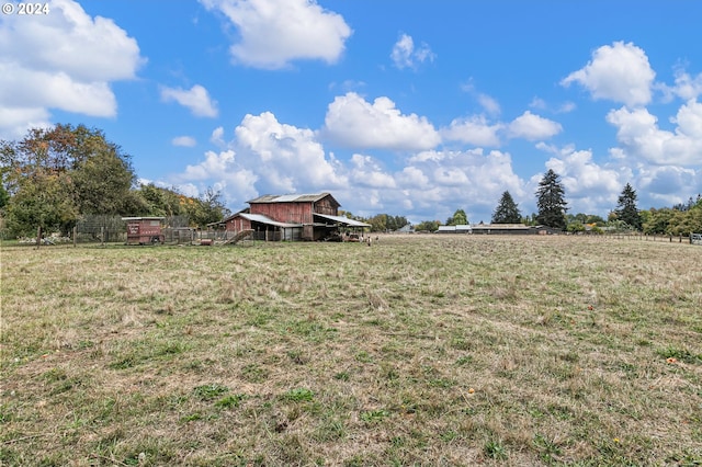 view of yard with an outdoor structure, a rural view, and a barn