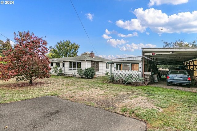 view of front of house with a front lawn and a carport