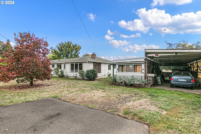 single story home featuring a carport and a front lawn