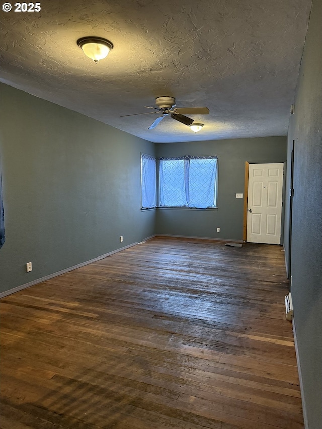 spare room featuring a textured ceiling, ceiling fan, and dark wood-type flooring