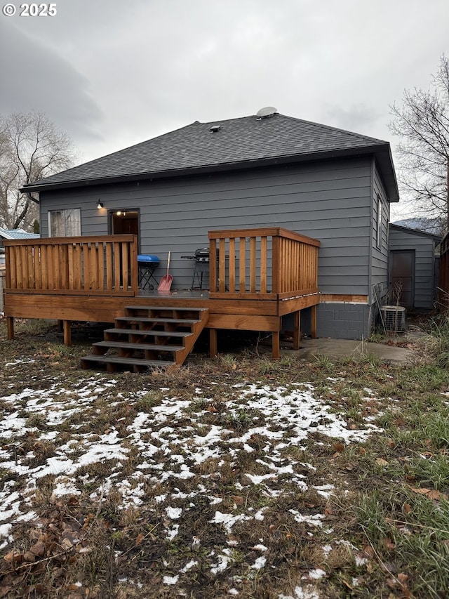 snow covered back of property featuring a deck