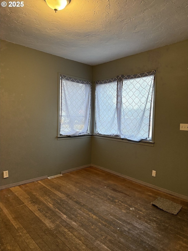 spare room with hardwood / wood-style floors and a textured ceiling