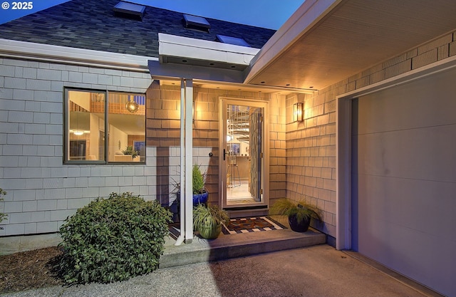 entrance to property featuring a shingled roof