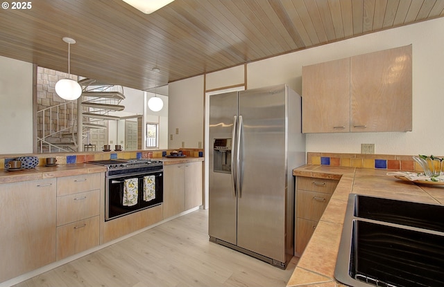 kitchen featuring light countertops, light brown cabinets, light wood-style floors, and appliances with stainless steel finishes