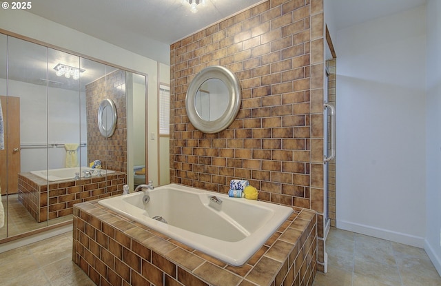 full bathroom featuring tile patterned floors, a garden tub, toilet, baseboards, and tiled shower