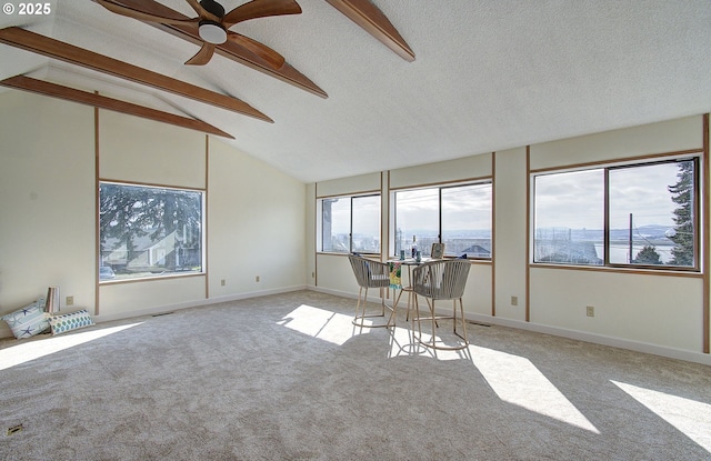 interior space featuring lofted ceiling with beams, a ceiling fan, and visible vents