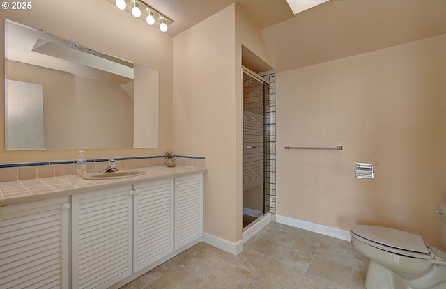 bathroom featuring baseboards, toilet, a stall shower, and vanity