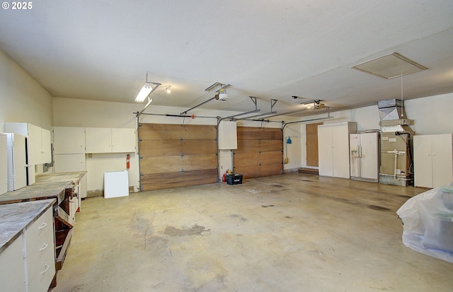 garage with a garage door opener and white fridge with ice dispenser