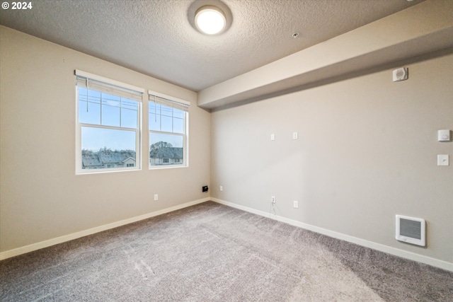 empty room featuring carpet flooring and a textured ceiling