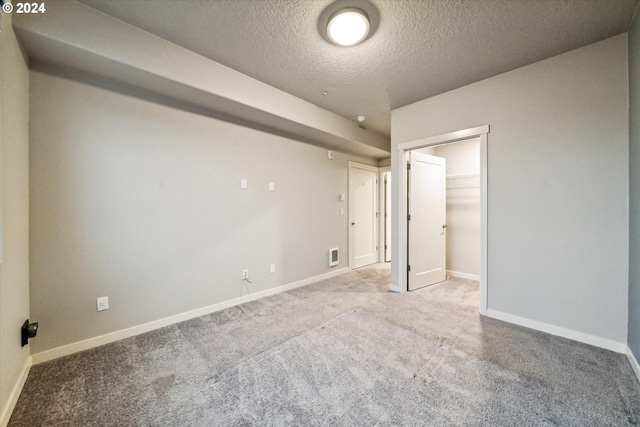 carpeted spare room featuring a textured ceiling