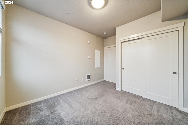 unfurnished bedroom featuring a closet, light colored carpet, and a textured ceiling