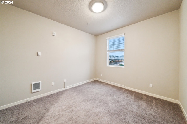 carpeted spare room with a textured ceiling