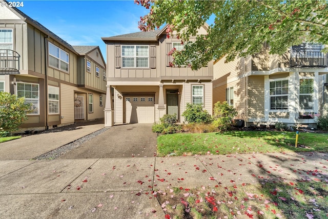 view of front of property with a balcony, a front lawn, and a garage