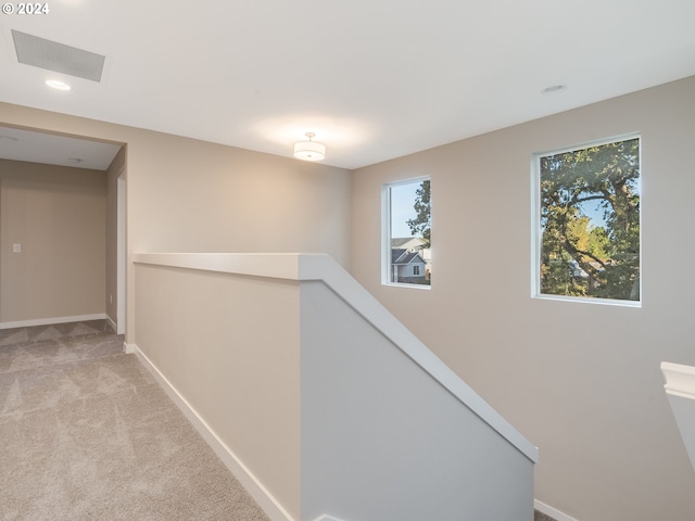 hall featuring light colored carpet