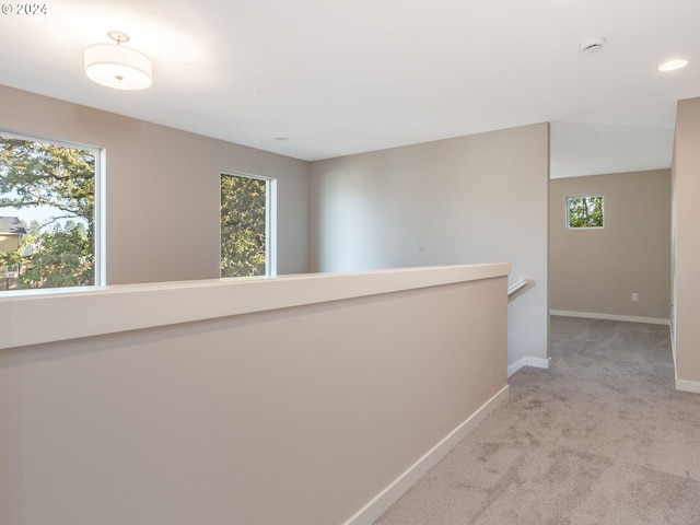 hall featuring light colored carpet