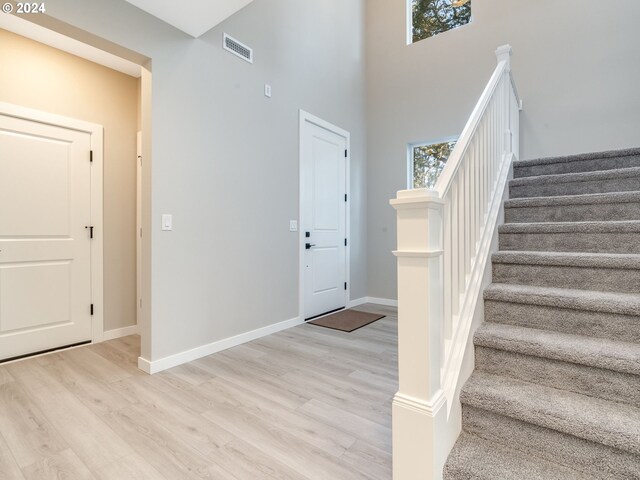 entryway with light hardwood / wood-style floors and a high ceiling