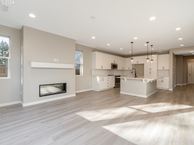 unfurnished living room with light wood-type flooring and sink