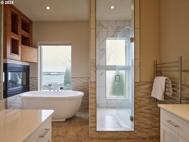 bathroom featuring tile walls, tile patterned flooring, vanity, and separate shower and tub