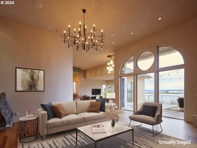 living room with a notable chandelier, a high ceiling, and hardwood / wood-style flooring