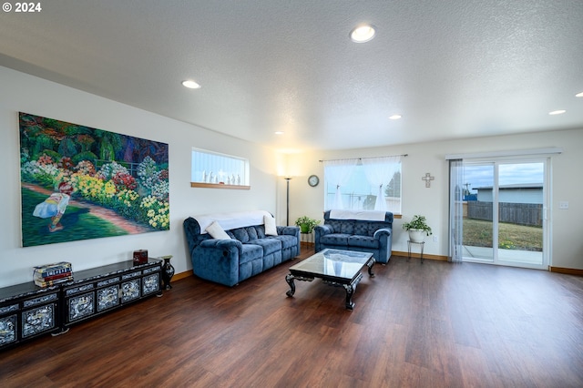 living room with dark hardwood / wood-style flooring and a textured ceiling