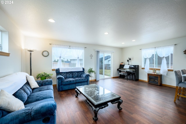 living room with dark hardwood / wood-style flooring and a textured ceiling