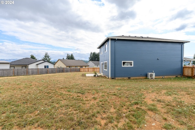 rear view of property featuring ac unit and a lawn