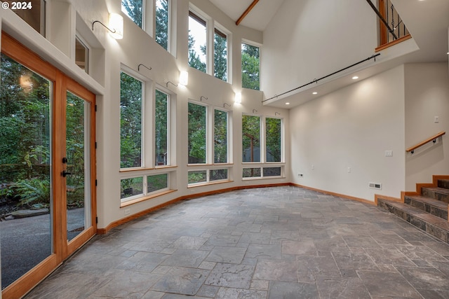 interior space with plenty of natural light, a skylight, and high vaulted ceiling