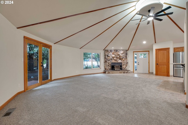 unfurnished living room with ceiling fan, light tile patterned flooring, and vaulted ceiling