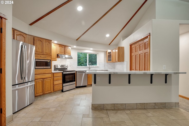 kitchen featuring sink, vaulted ceiling, decorative backsplash, stainless steel appliances, and light tile patterned floors