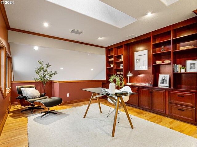 office area featuring built in shelves, light hardwood / wood-style flooring, and ornamental molding