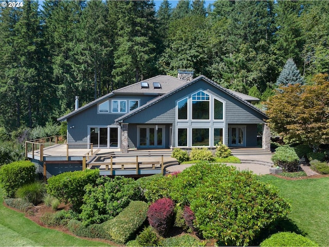 rear view of house featuring a wooden deck and french doors